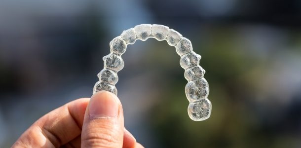 Hand holding a clear aligner