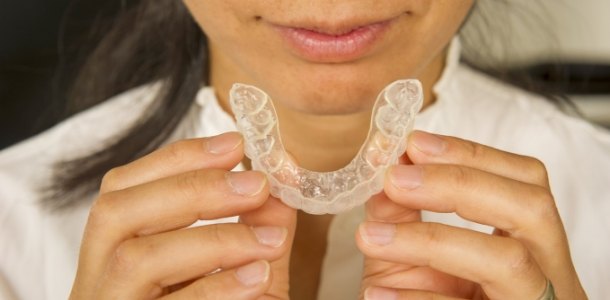 Woman holding a clear aligner