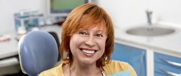 Redheaded woman smiling in dental chair