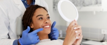 Dental patient admiring her smile in mirror