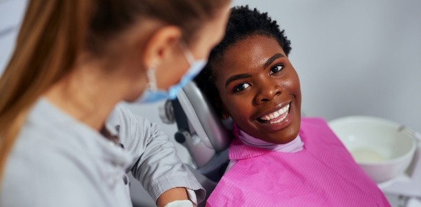 Person in dental chair smiling at their dentist
