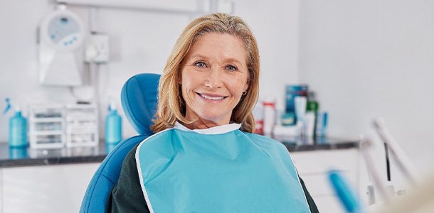 Female patient sitting in dental chair smiling