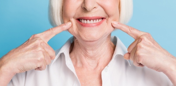 Senior woman pointing to her smile