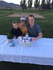 Doctor May sitting at outdoor table with his wife and child