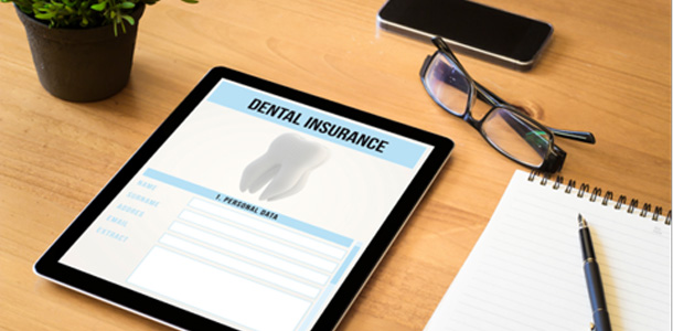 Tablet with dental insurance form and nearby glasses 