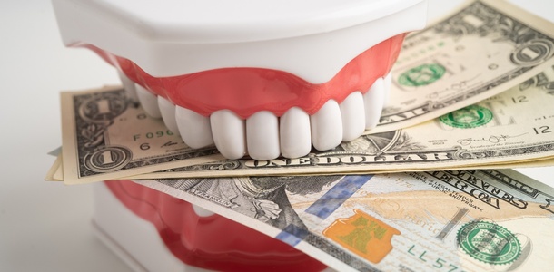 False teeth biting dollar bills