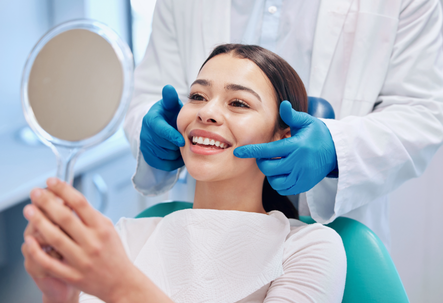 Patient smiling into mirror at dental appointment